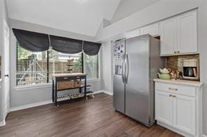 kitchen featuring white cabinetry, vaulted ceiling, dark hardwood / wood-style floors, and stainless steel fridge with ice dispenser