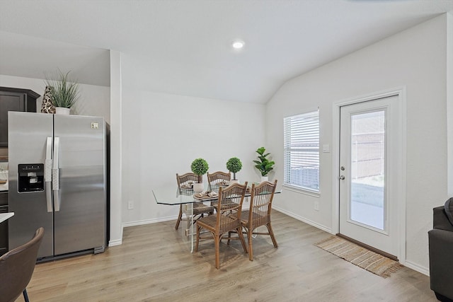 dining room with lofted ceiling and light hardwood / wood-style floors