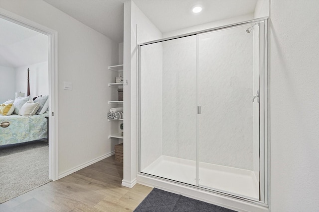 bathroom featuring wood-type flooring and a shower with door