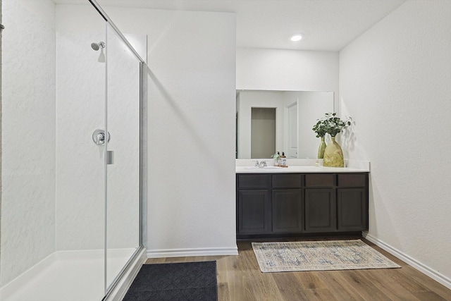 bathroom with vanity, hardwood / wood-style floors, and a shower with shower door