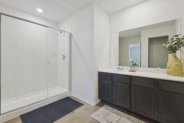 bathroom featuring vanity, hardwood / wood-style floors, and a shower with door