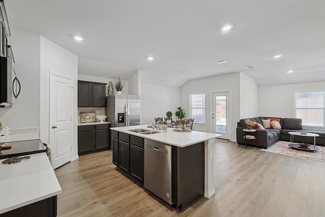 kitchen featuring sink, dark brown cabinets, appliances with stainless steel finishes, an island with sink, and light hardwood / wood-style floors