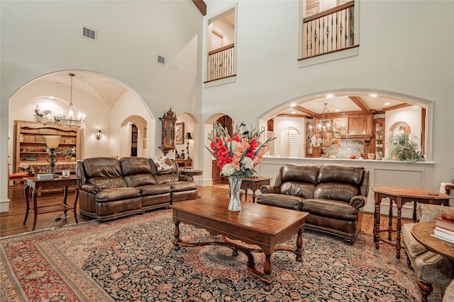 living room featuring hardwood / wood-style floors, a chandelier, and a high ceiling