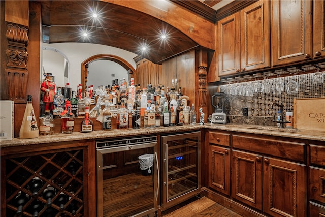 bar with sink, hardwood / wood-style floors, wine cooler, and light stone counters