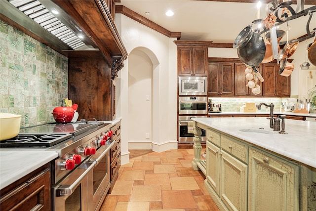 kitchen with stainless steel appliances, custom exhaust hood, sink, and backsplash