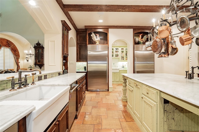 kitchen with tasteful backsplash, light stone countertops, stainless steel appliances, and cream cabinetry