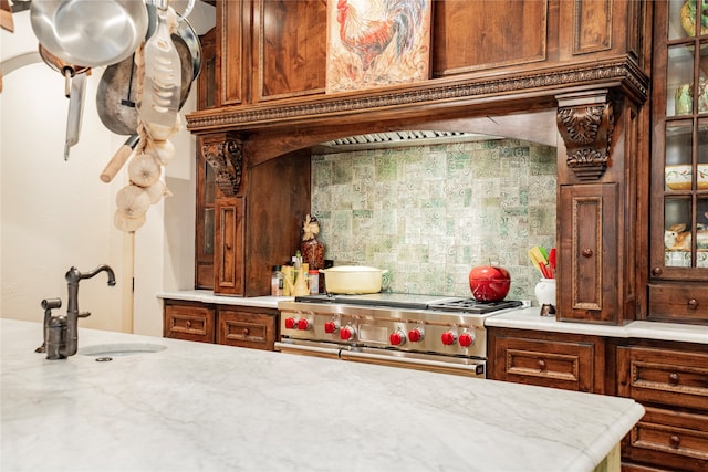 kitchen with range with two ovens, sink, and backsplash