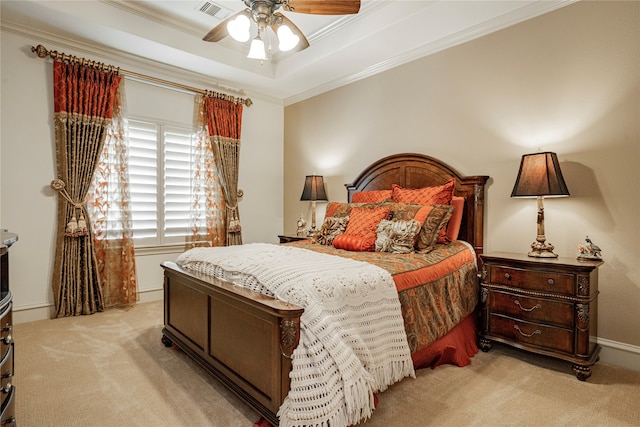 bedroom featuring crown molding, light colored carpet, a tray ceiling, and ceiling fan