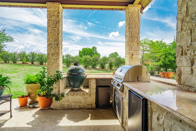 view of patio / terrace featuring an outdoor kitchen and a grill