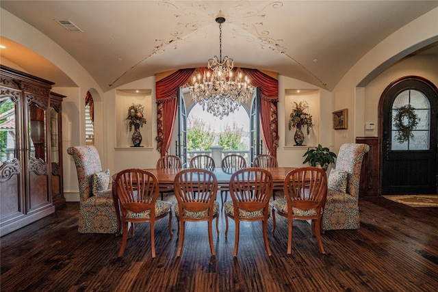 dining area featuring lofted ceiling, dark hardwood / wood-style flooring, and a chandelier