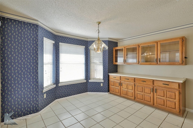 kitchen featuring pendant lighting, crown molding, a textured ceiling, and light tile patterned floors