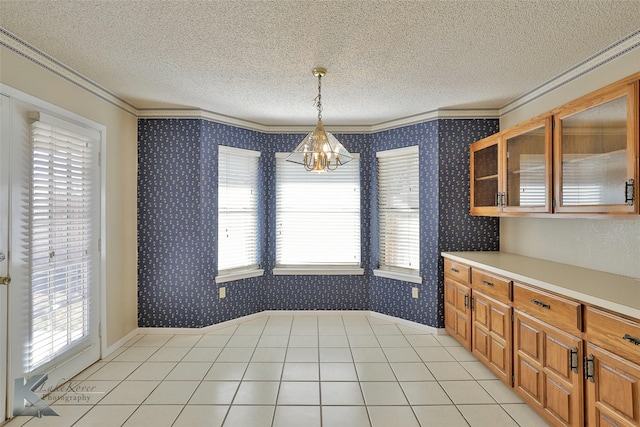 unfurnished dining area with ornamental molding, a healthy amount of sunlight, and a textured ceiling