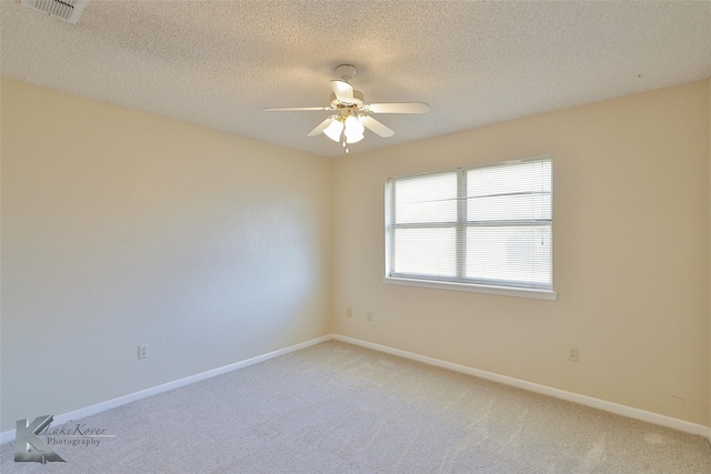 spare room featuring ceiling fan, carpet flooring, and a textured ceiling