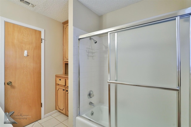 bathroom with enclosed tub / shower combo, tile patterned floors, and a textured ceiling