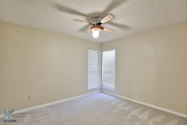 carpeted spare room with a textured ceiling and ceiling fan