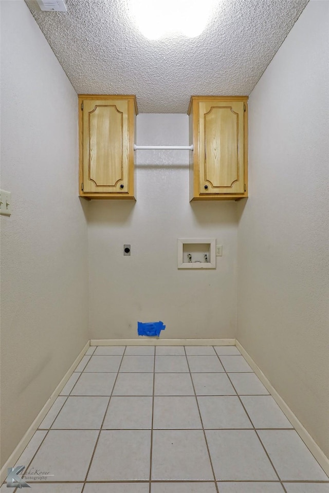 washroom with light tile patterned floors, cabinets, washer hookup, a textured ceiling, and hookup for an electric dryer