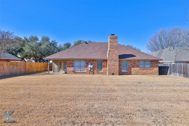 rear view of property with a lawn