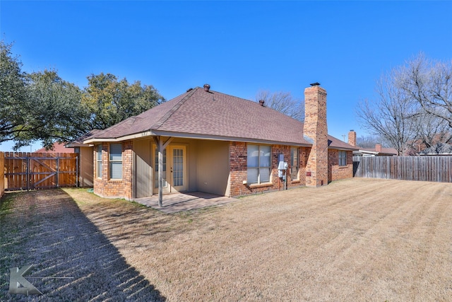 back of property with french doors, a yard, and a patio