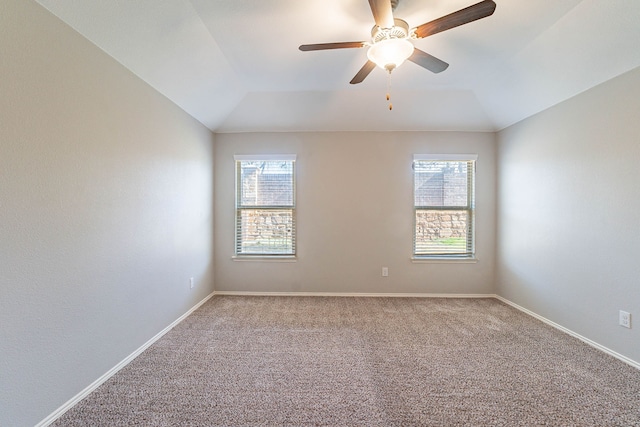 carpeted spare room featuring ceiling fan, lofted ceiling, and a healthy amount of sunlight