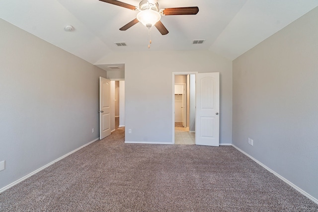 unfurnished bedroom featuring light carpet, connected bathroom, vaulted ceiling, and ceiling fan