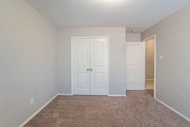 unfurnished bedroom featuring carpet floors, a closet, and a textured ceiling