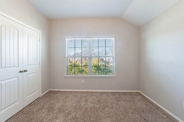 interior space featuring lofted ceiling, a closet, and carpet flooring