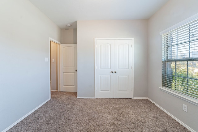 unfurnished bedroom featuring carpet floors and a closet