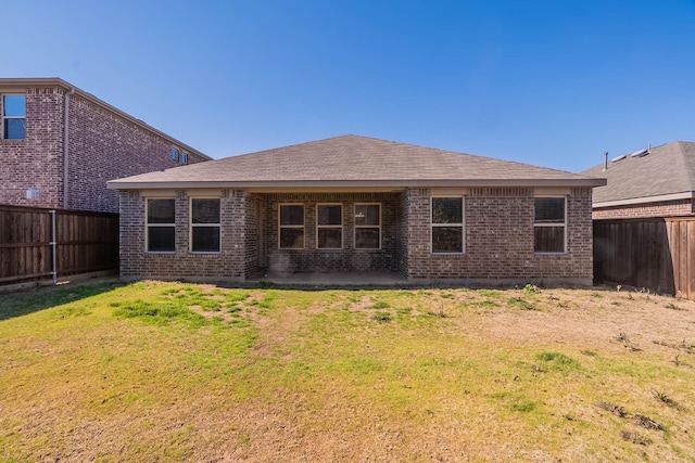 back of house with a patio area and a lawn