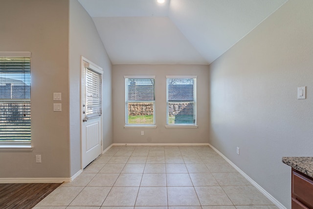 entrance foyer featuring vaulted ceiling and light tile patterned floors