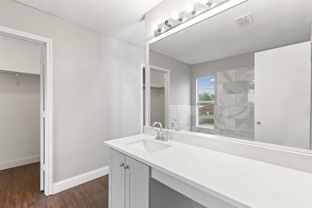 bathroom with hardwood / wood-style flooring, vanity, and a textured ceiling