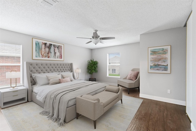 bedroom featuring ceiling fan, light hardwood / wood-style flooring, and a textured ceiling