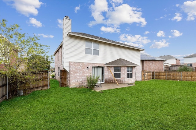 rear view of house featuring a patio and a lawn