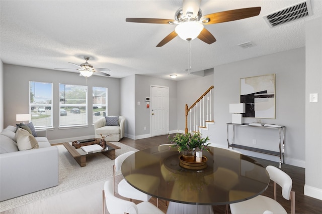 living room with ceiling fan, hardwood / wood-style floors, and a textured ceiling