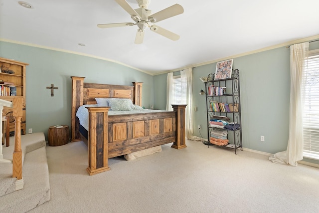 carpeted bedroom with ceiling fan, crown molding, and lofted ceiling