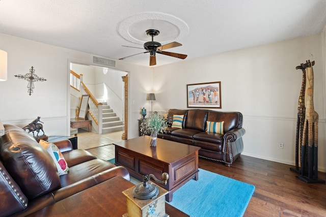 living room with ceiling fan, wood-type flooring, and a textured ceiling