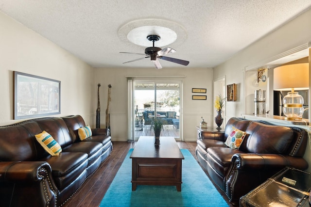 living room featuring a textured ceiling, ceiling fan, and dark hardwood / wood-style floors