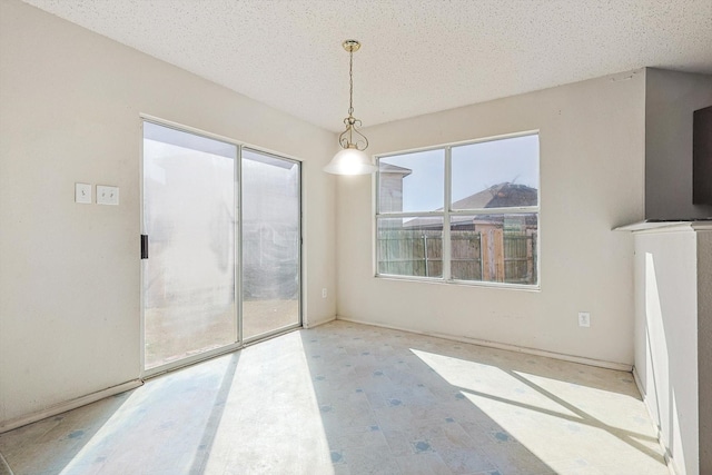 unfurnished dining area with a textured ceiling