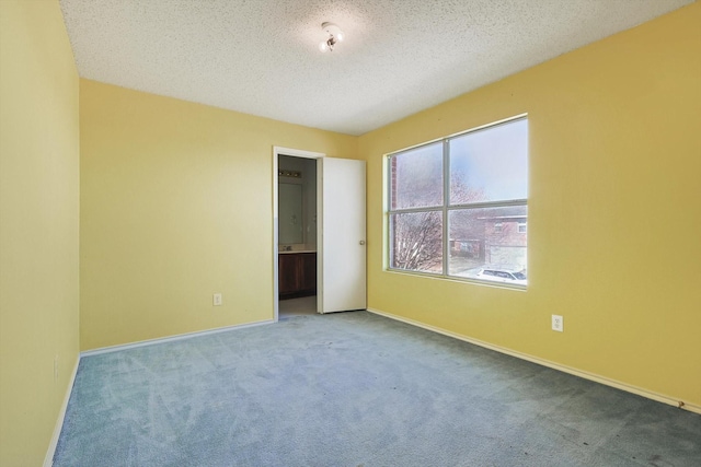 unfurnished room with carpet floors and a textured ceiling