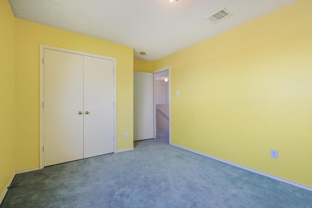 unfurnished bedroom featuring carpet flooring, a closet, and a textured ceiling