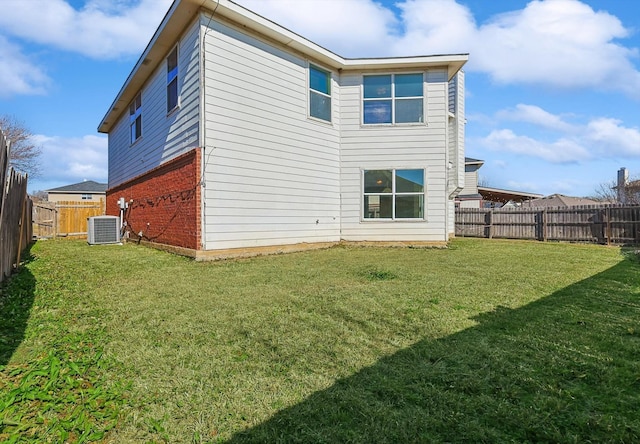 back of house with a lawn and central air condition unit