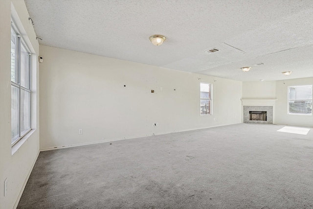 unfurnished living room featuring a textured ceiling and carpet flooring