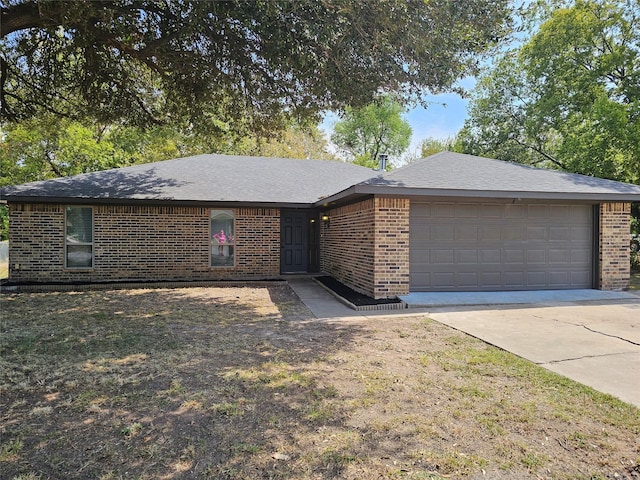 single story home featuring driveway, a garage, and brick siding