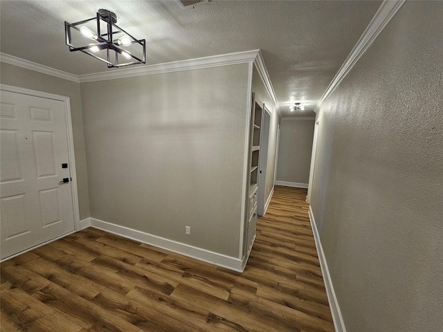 foyer entrance with ornamental molding, dark hardwood / wood-style floors, and a notable chandelier