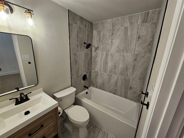 full bathroom with tiled shower / bath, vanity, toilet, and a textured ceiling