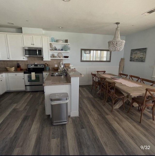 kitchen with sink, hanging light fixtures, dark hardwood / wood-style flooring, stainless steel appliances, and white cabinets