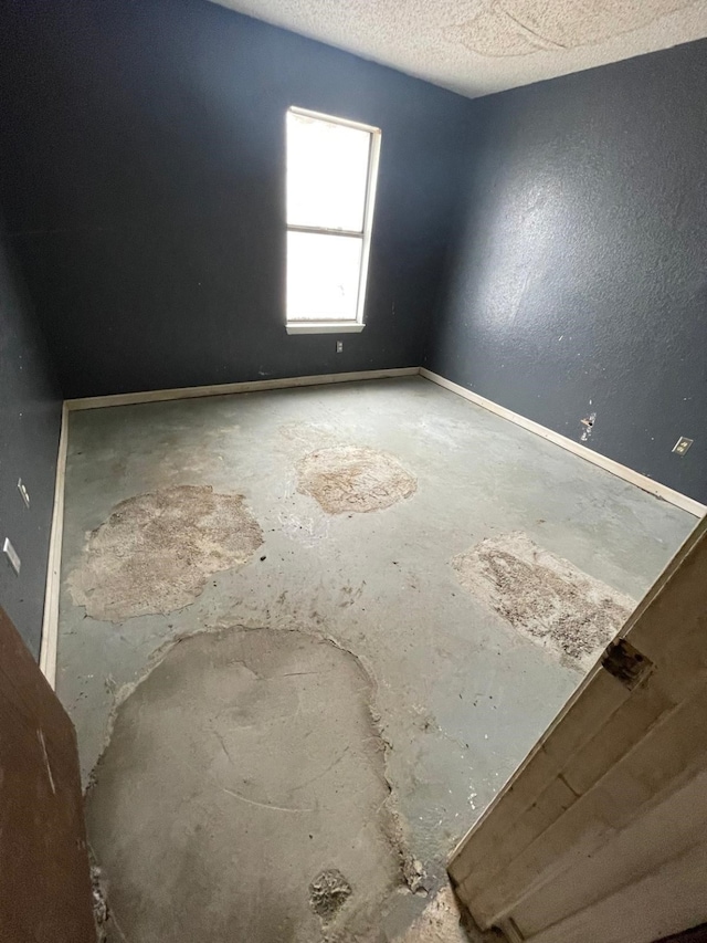 unfurnished room with a textured ceiling