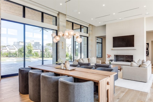 interior space featuring a high ceiling, a large fireplace, and light hardwood / wood-style floors