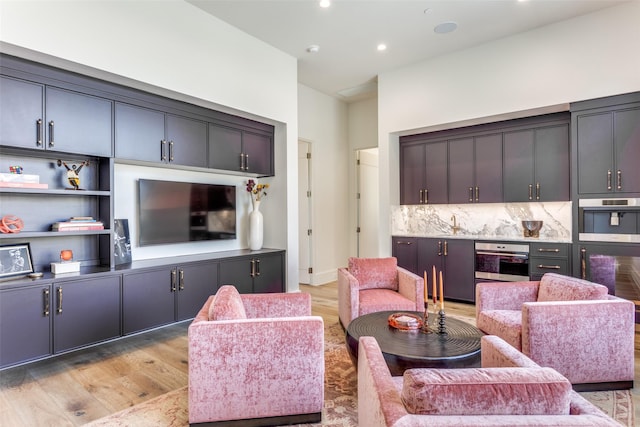 living room featuring bar and light hardwood / wood-style floors