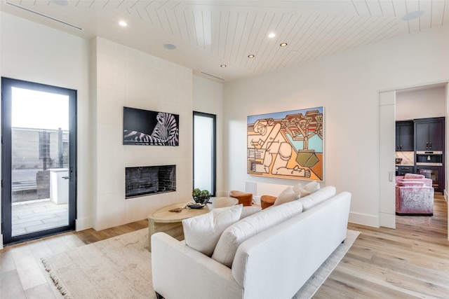 living room featuring wood ceiling, a fireplace, and light hardwood / wood-style flooring