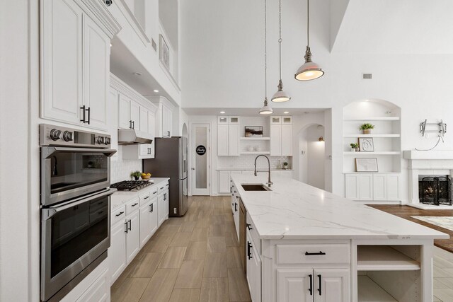 kitchen featuring a kitchen island with sink, sink, white cabinetry, and stainless steel appliances